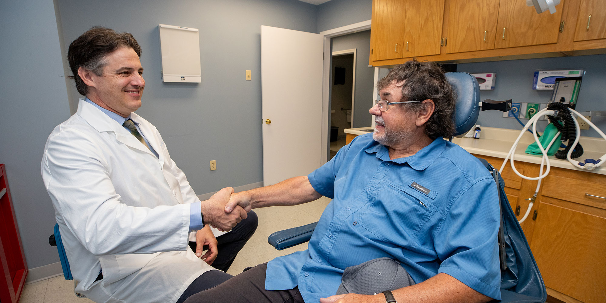 patient shaking hands with doctor within the dental practice